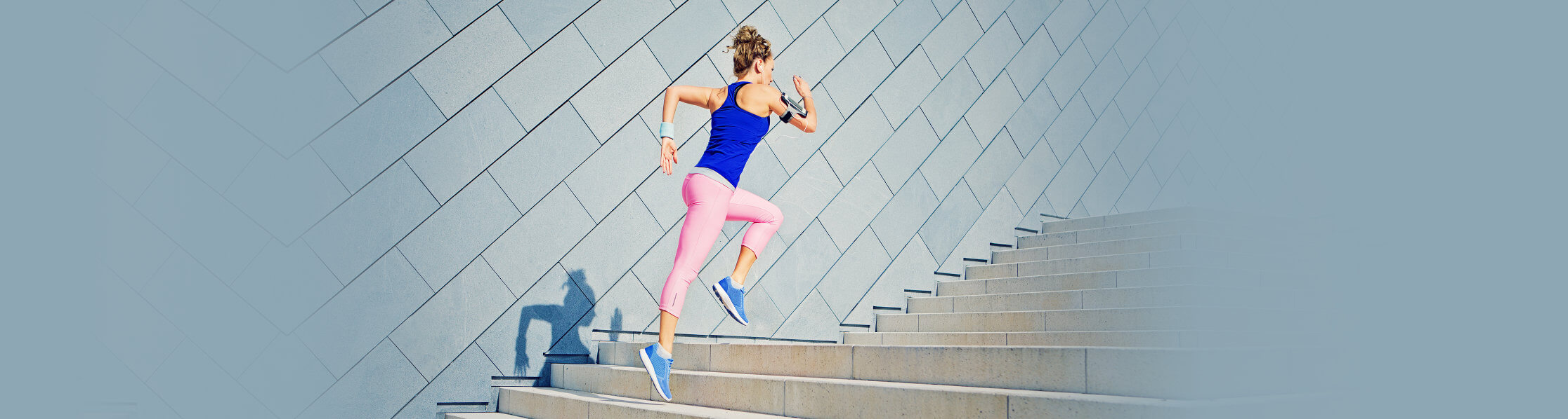 woman in running outfit jogging up a flight of stairs