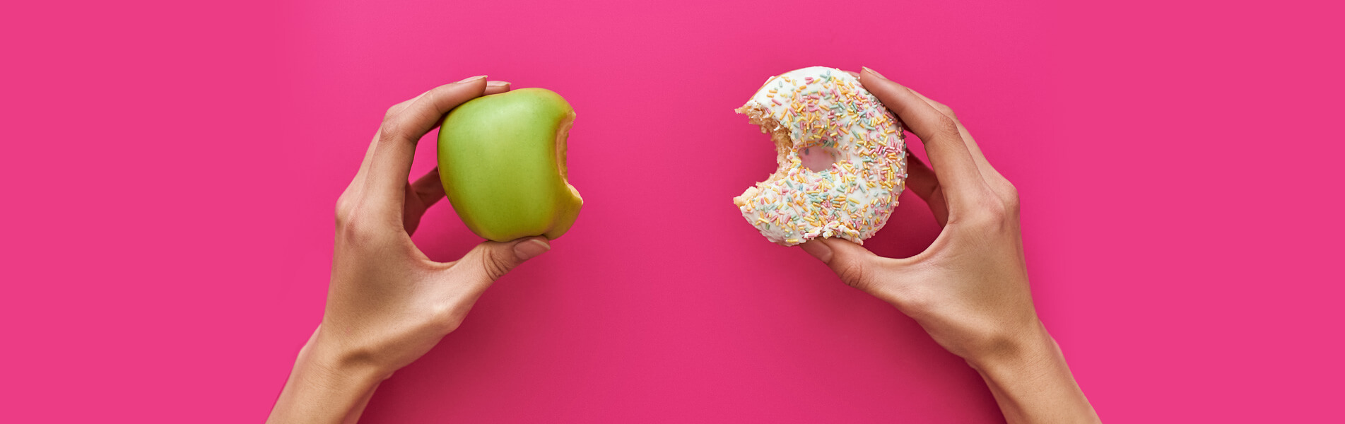 Young woman trying to choose between apple and donut